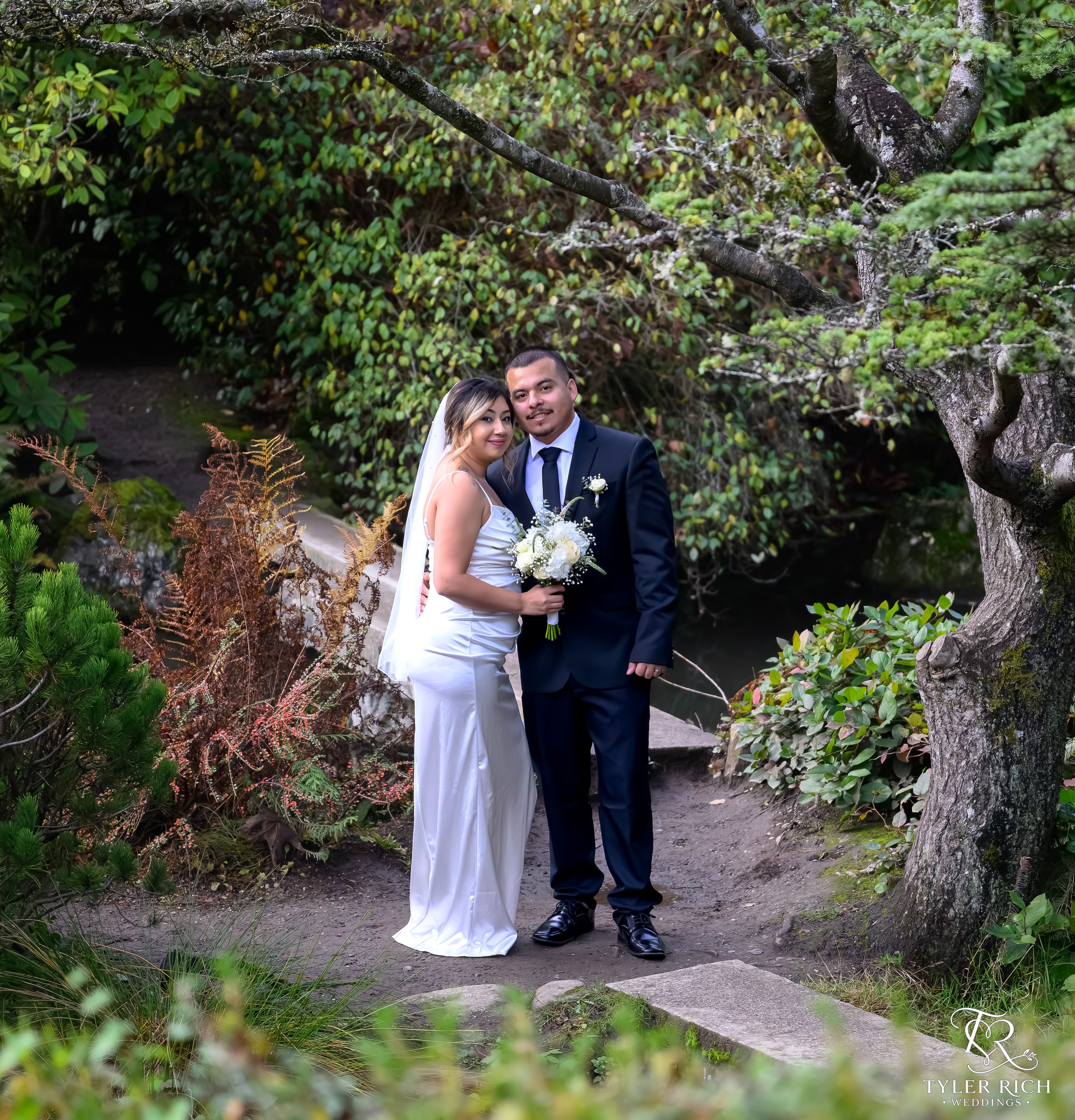 Newlyweds posing in a garden