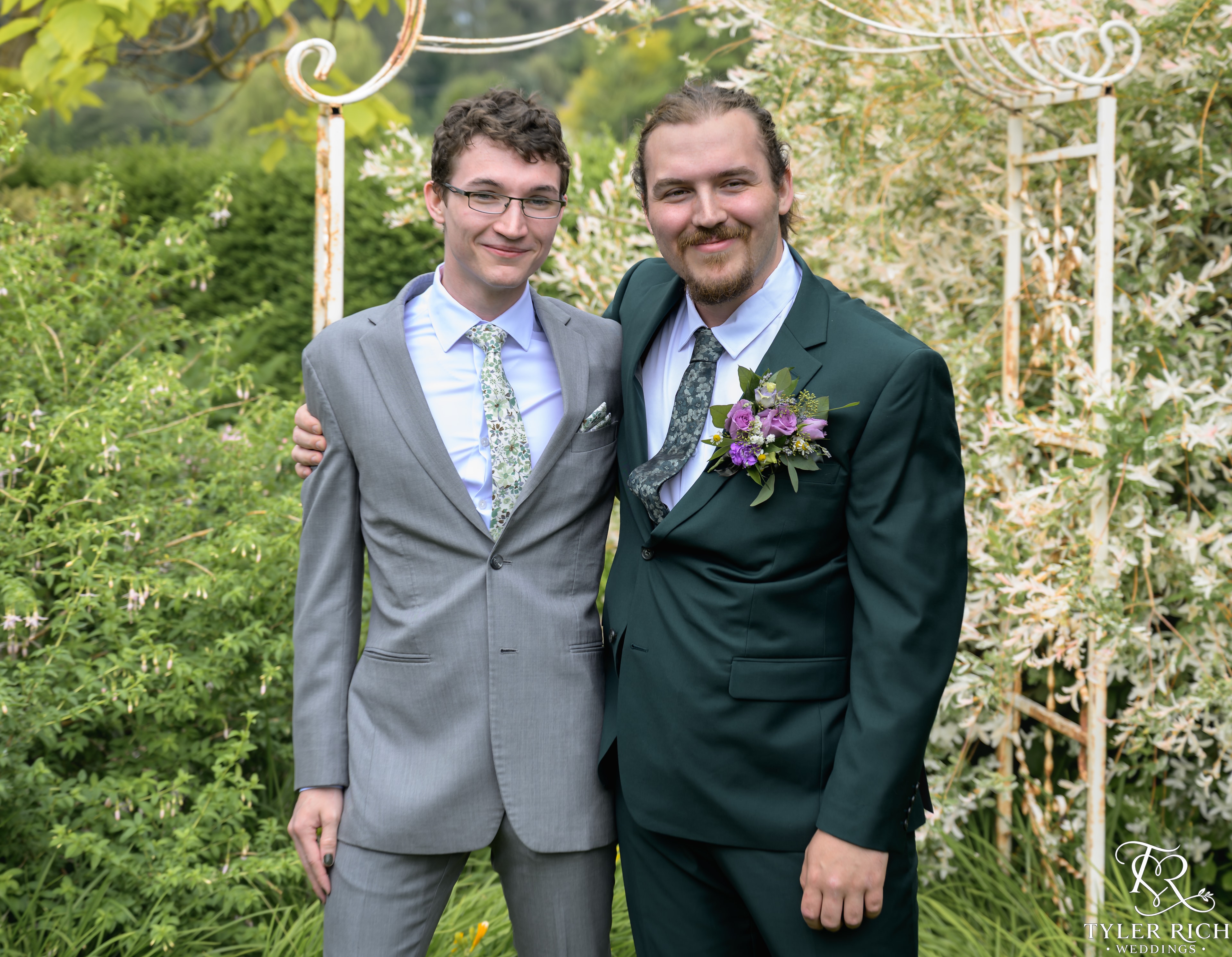 Grooms posing together in a garden
